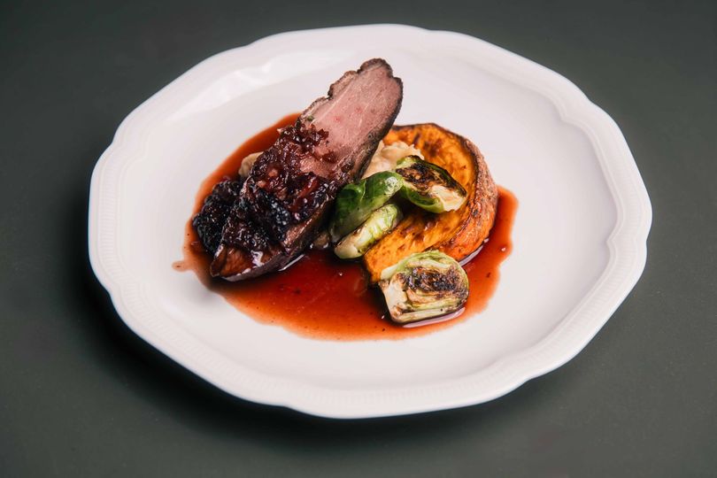 Un chef prépare de la nourriture sur une planche à découper en bois.