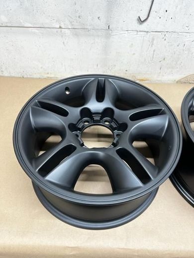 A pair of black powder coated wheels are sitting on a table