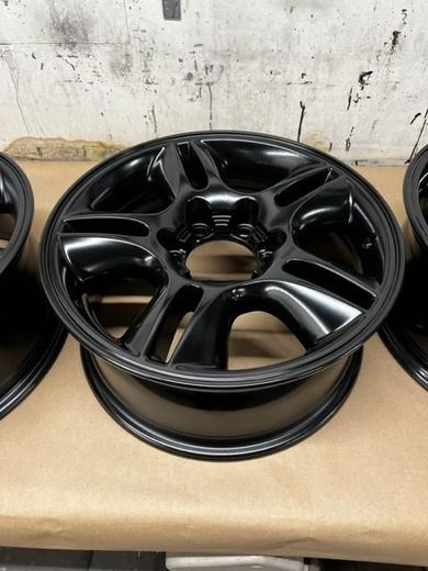 Three black powder coated wheels are sitting on a table