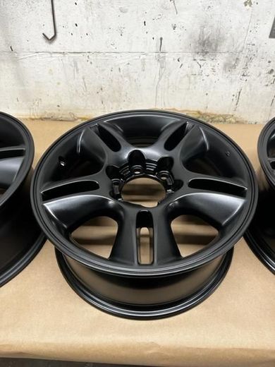 Three black powder coated wheels are sitting on a table