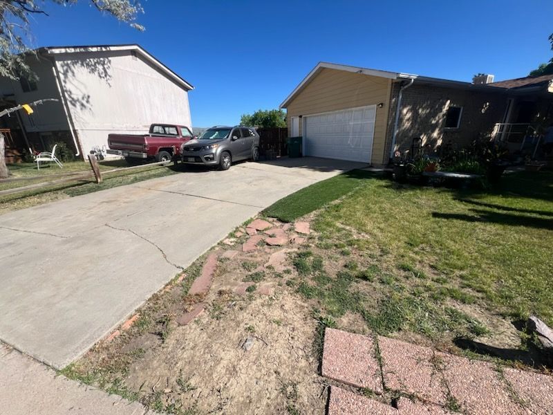 A car is parked in a driveway in front of a house.