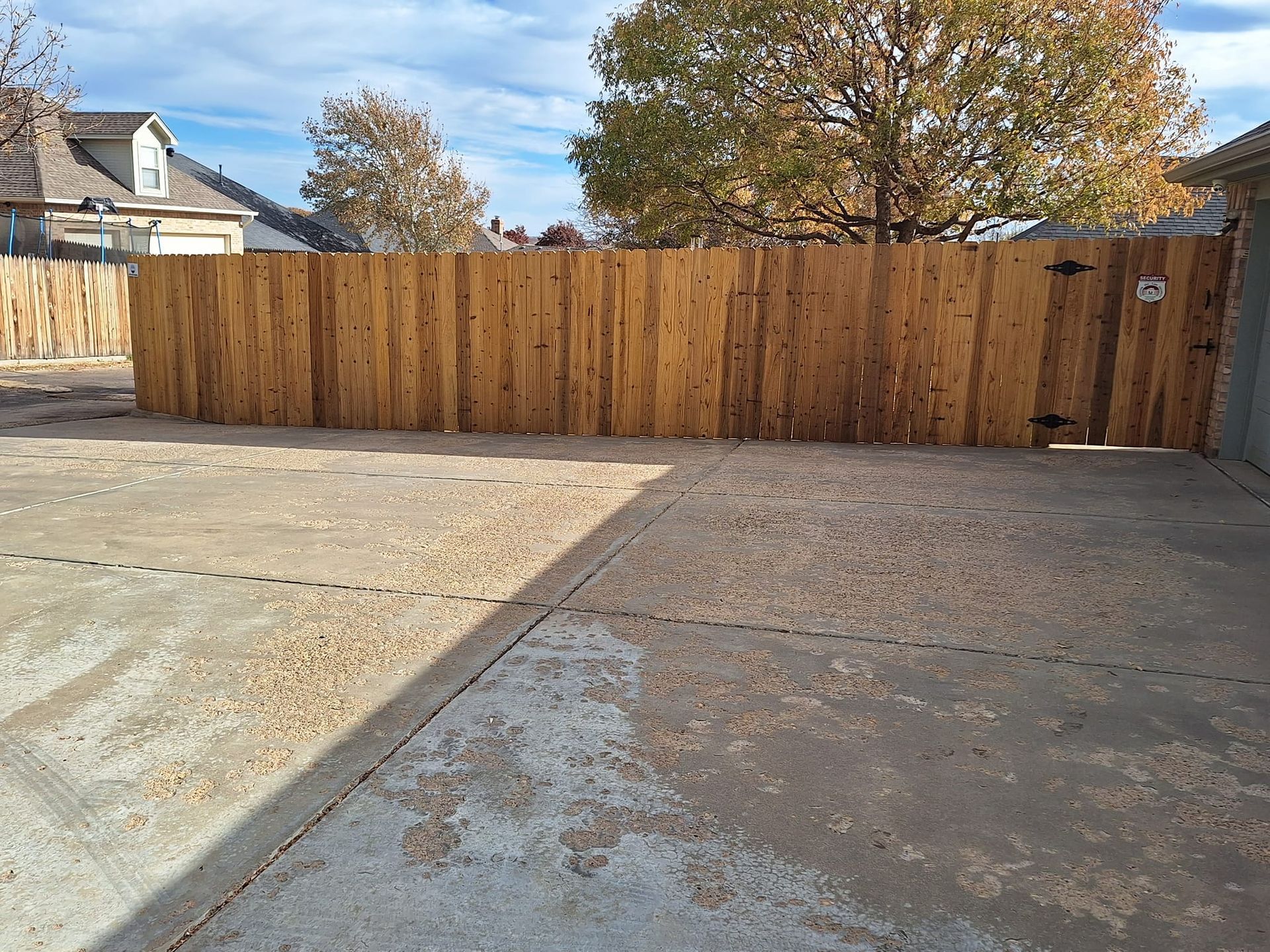 Concrete yard with a wooden fence and gate.