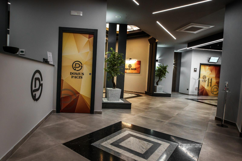 La hall di un albergo con pavimento in marmo e un cartello sulla porta.