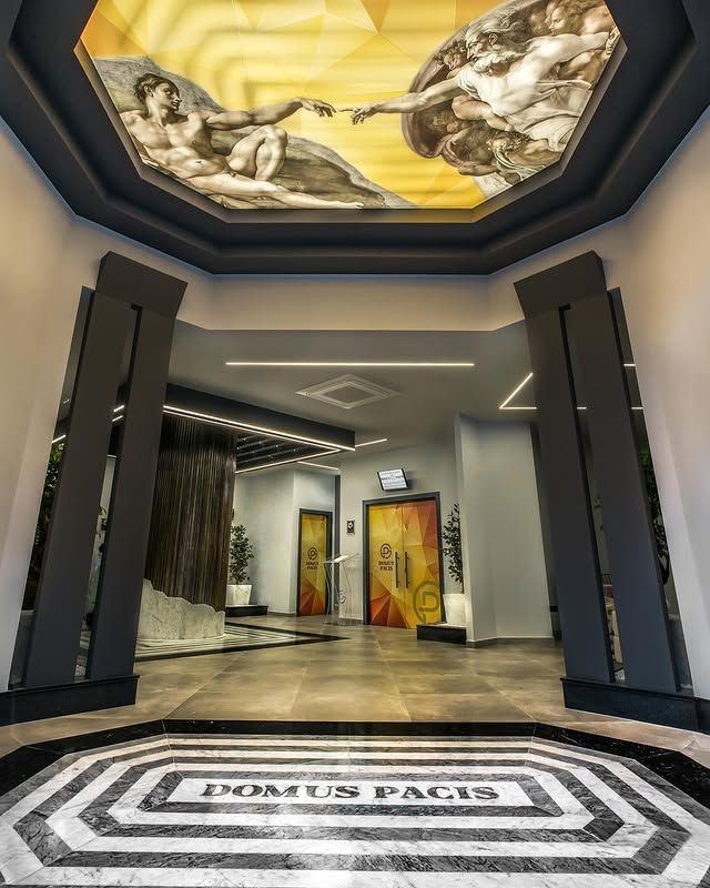 Un corridoio con un dipinto sul soffitto e un pavimento in marmo.