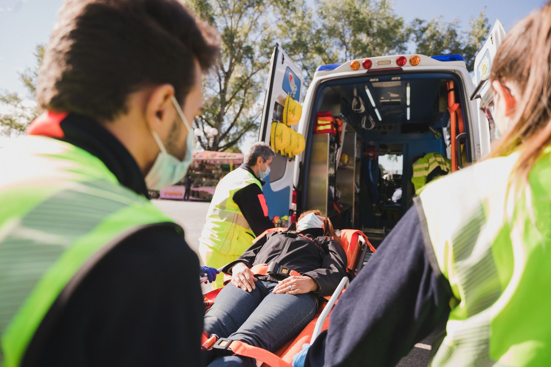 Una donna è sdraiata su una barella davanti a un'ambulanza.