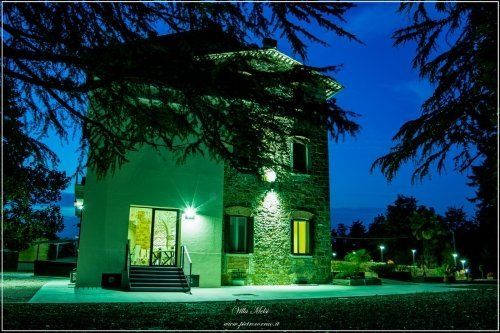 Vista notturna di edificio in pietra con alberi