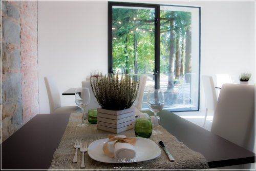 Tavola apparecchiata con stoviglie e piantina di erica