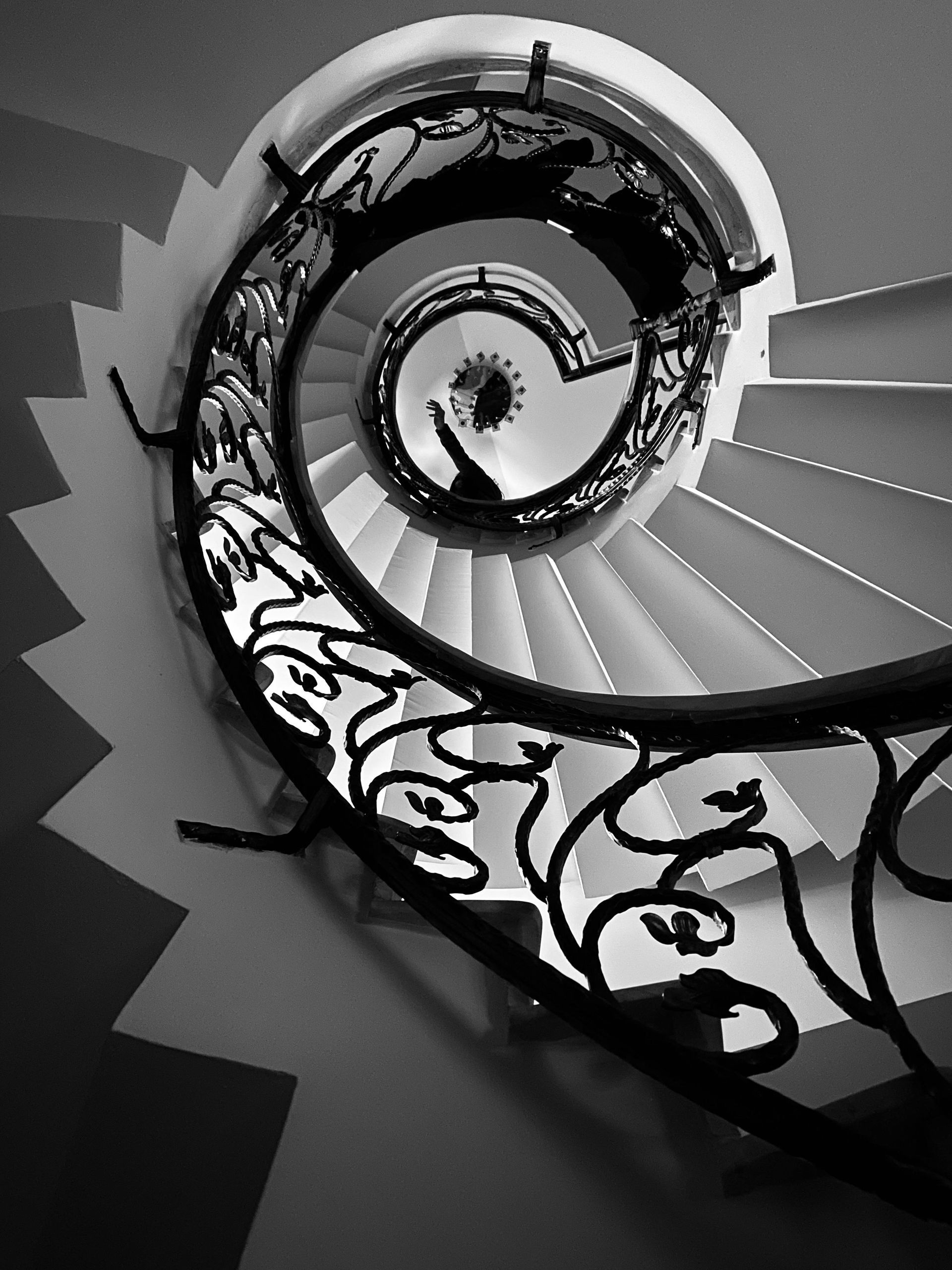 A black and white photo of a spiral staircase