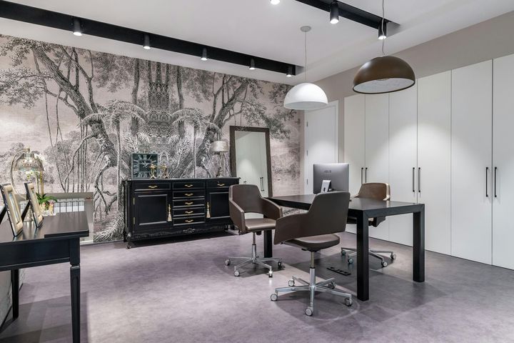 A room with a desk and chairs in it