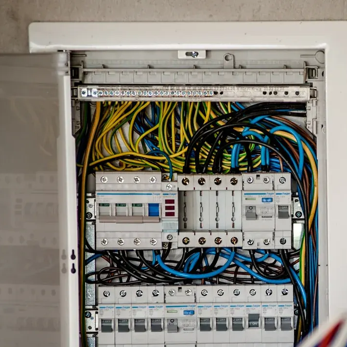 Two men are standing in an empty room with black walls