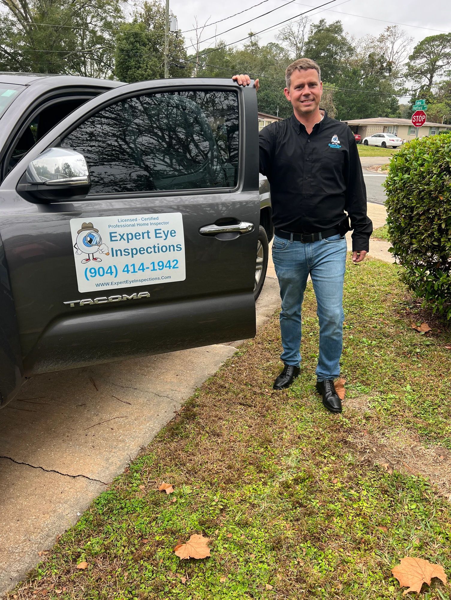 A man is standing in front of a truck with the door open.