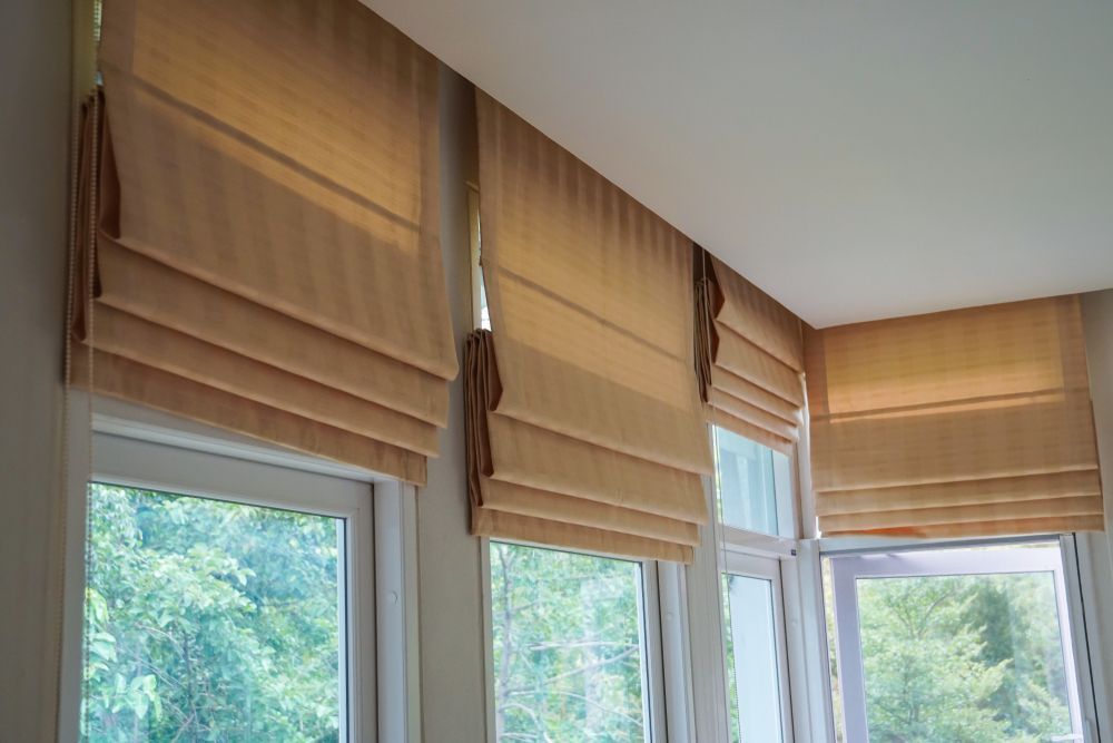 A Room With a Lot of Windows and Roman Shades on Them — Curtain Haven & Blinds in Laurieton, NSW