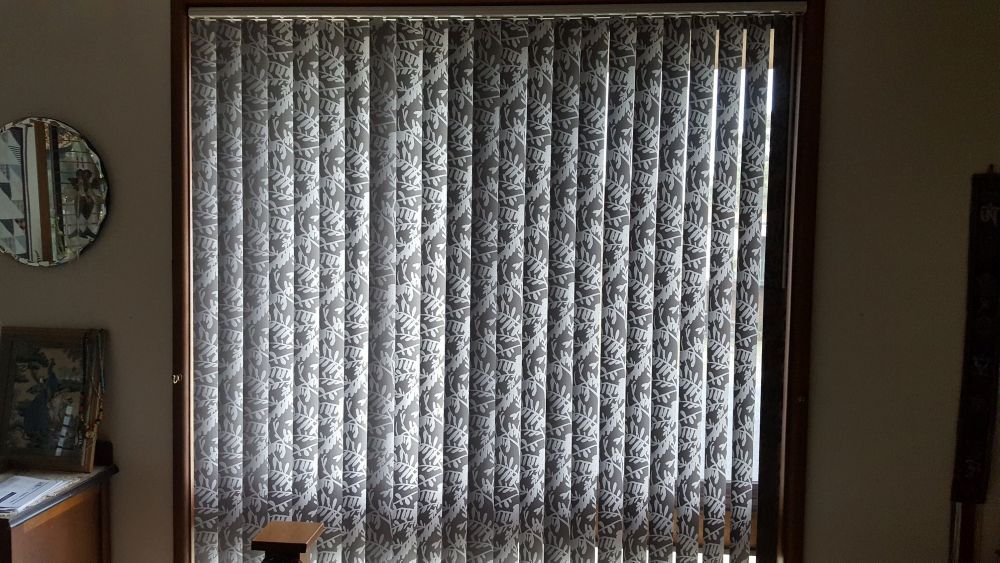 A Living Room With a Sliding Glass Door and Vertical Blinds — Curtain Haven & Blinds in Laurieton, NSW