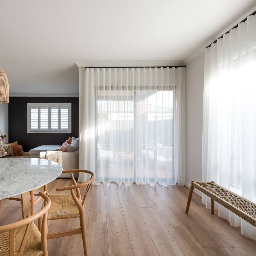 A Living Room With a Table and Chairs and White Curtains — Curtain Haven & Blinds in Laurieton, NSW