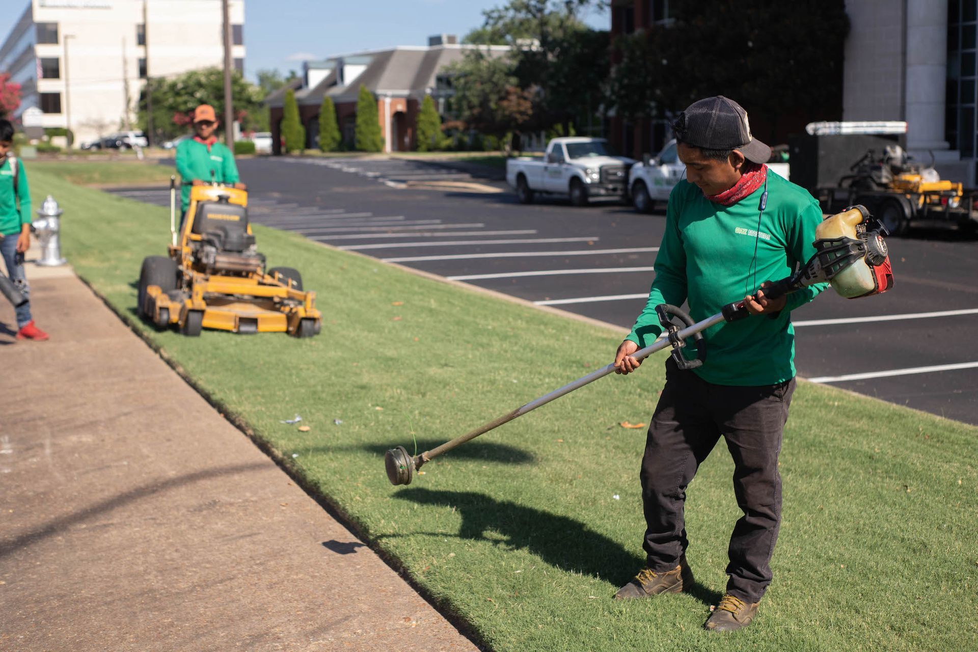 A man is trimming a lawn with a trimmer.