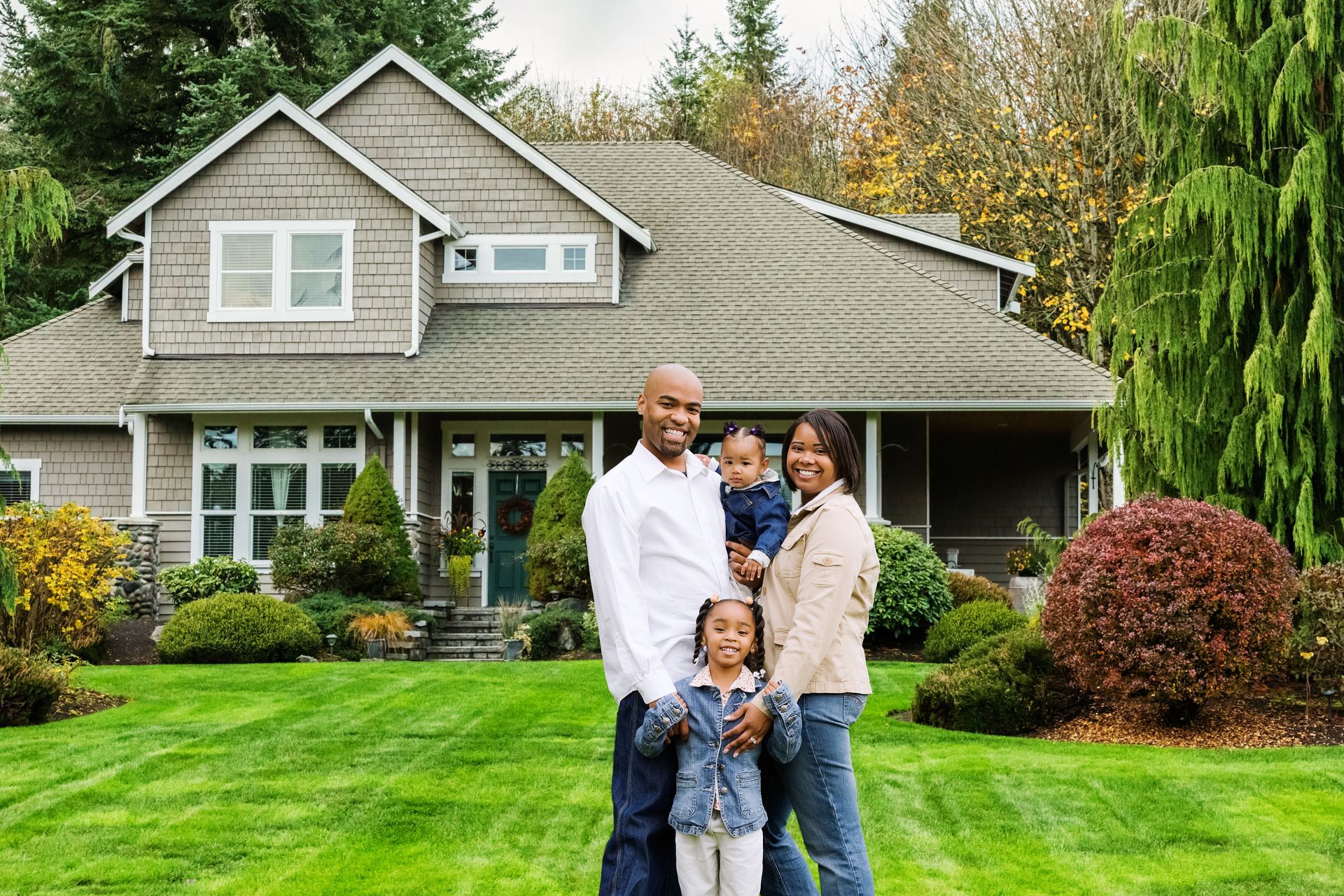 Happy family in front of a pest-free home.