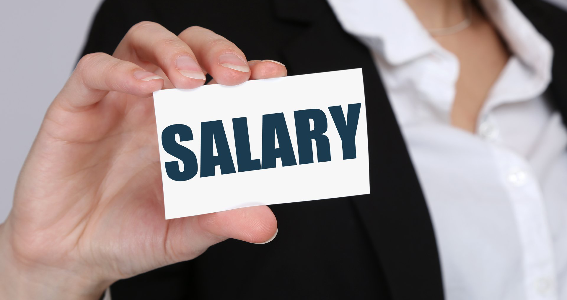 Picture of a professional woman holding up a card that says SALARY.