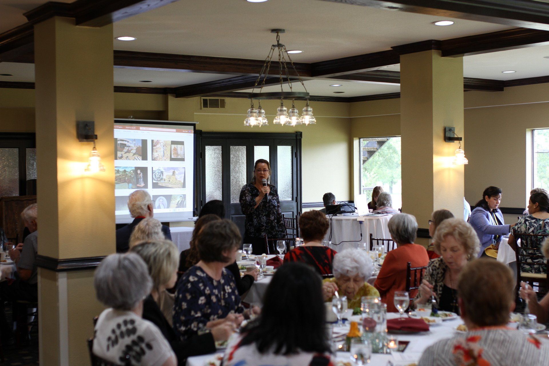A group of people are sitting at tables in a large room.