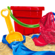 A red bucket with a green handle and a yellow shovel in the sandbox