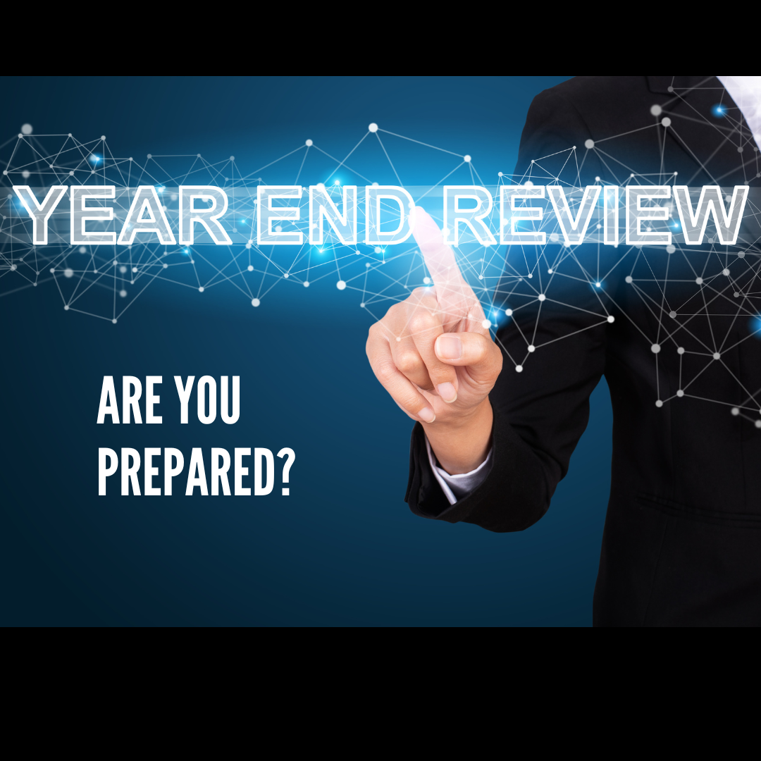 Woman in a suit pointing to title Year End Review - Are you prepared?