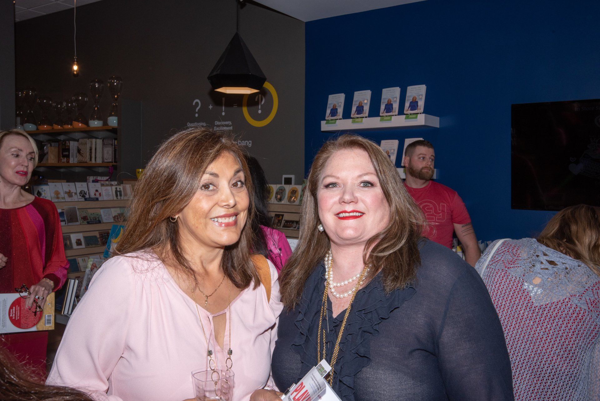 Two women are posing for a picture together in a room.