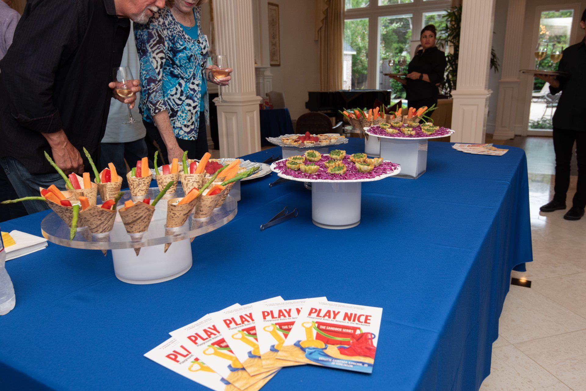 A table with a blue table cloth and a bunch of food on it