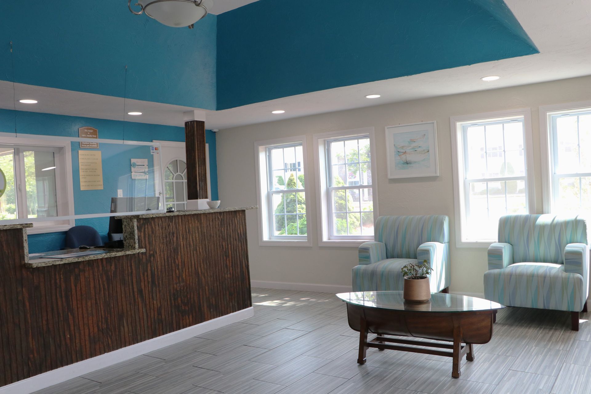 Lobby with reception desk and seating; blue ceiling and light-colored walls.