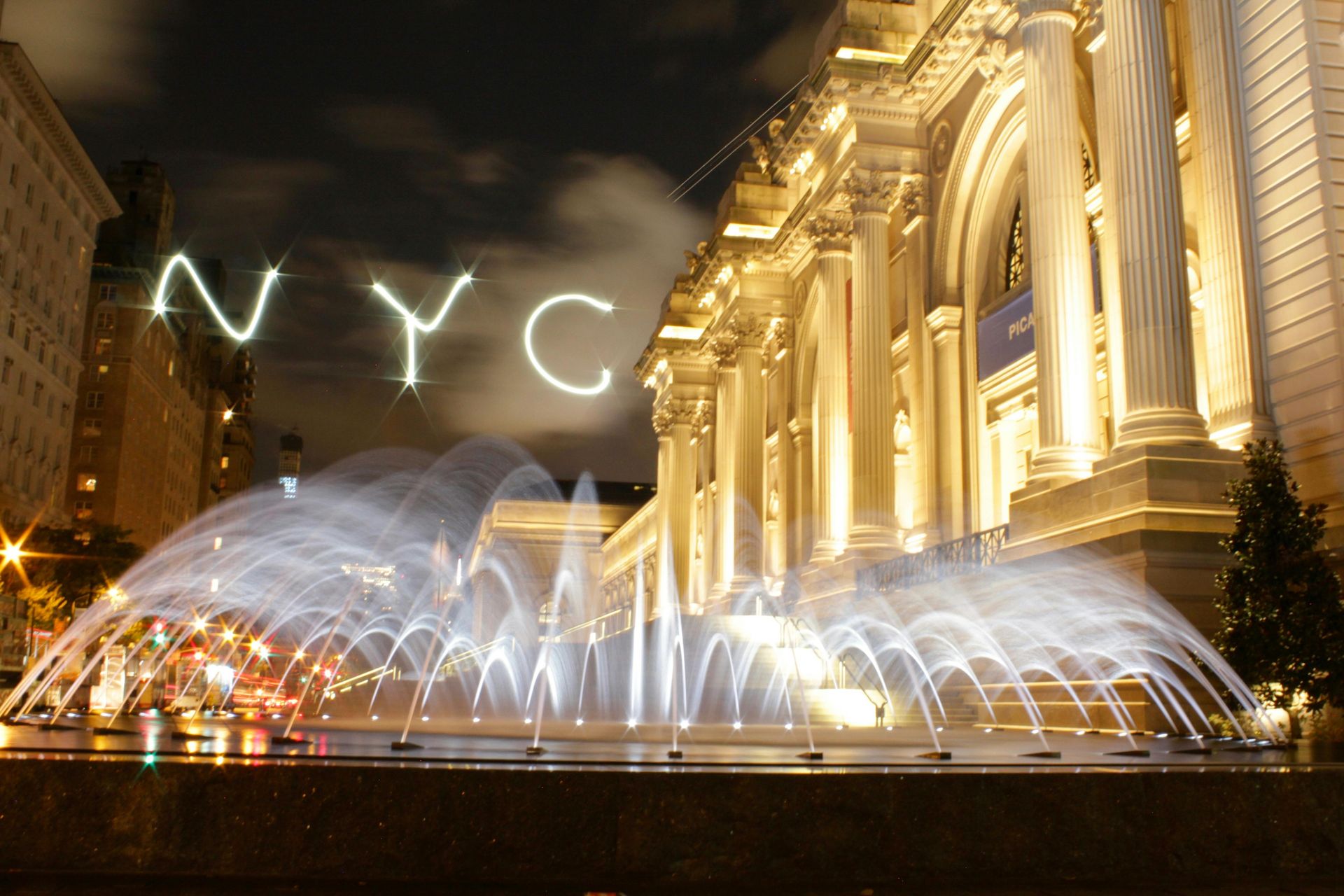 A fountain in front of a building that says nyc