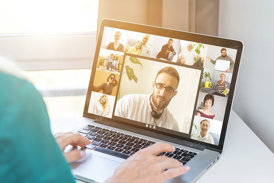 A person is using a laptop computer to have a video call with a group of people.