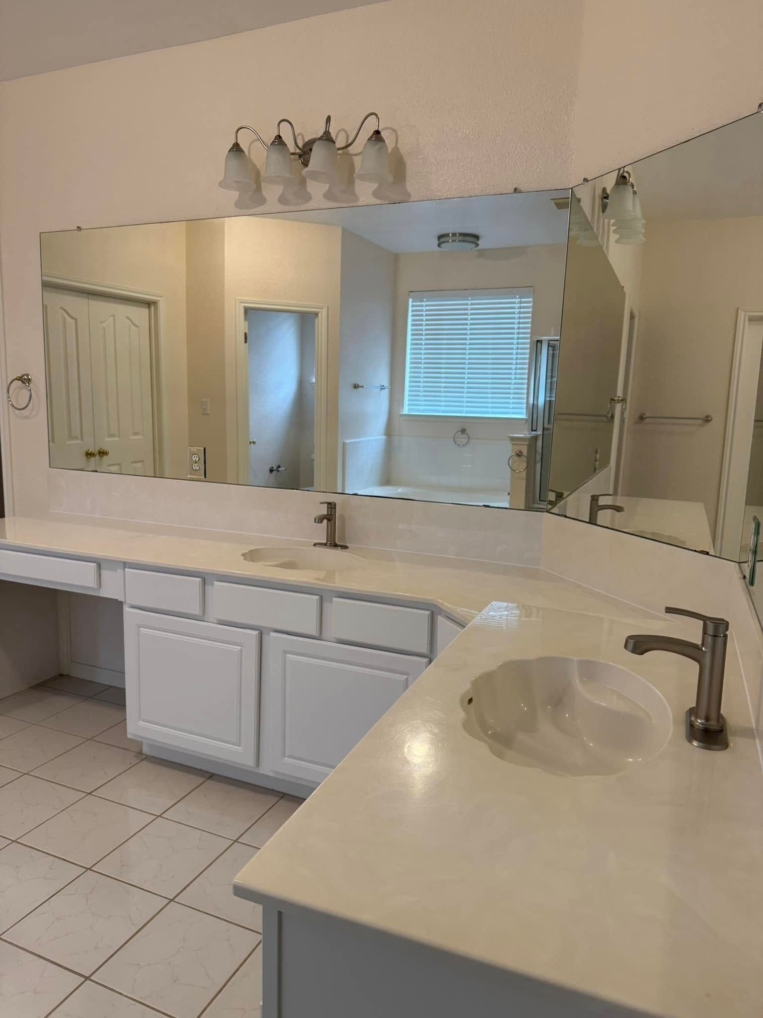 A bathroom with two sinks and a large mirror.