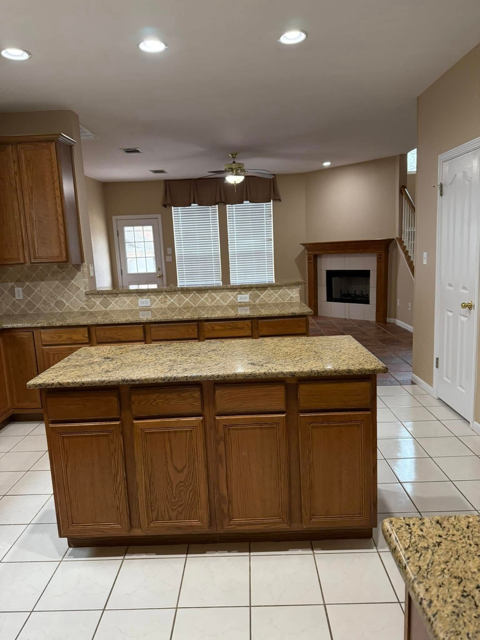 A kitchen with wooden cabinets and granite counter tops.