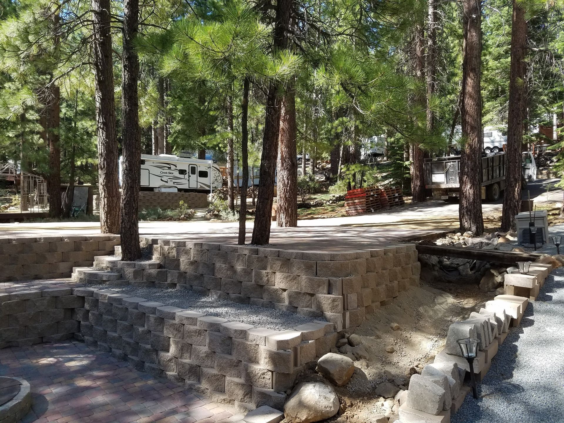 A rv is parked in the middle of a forest.