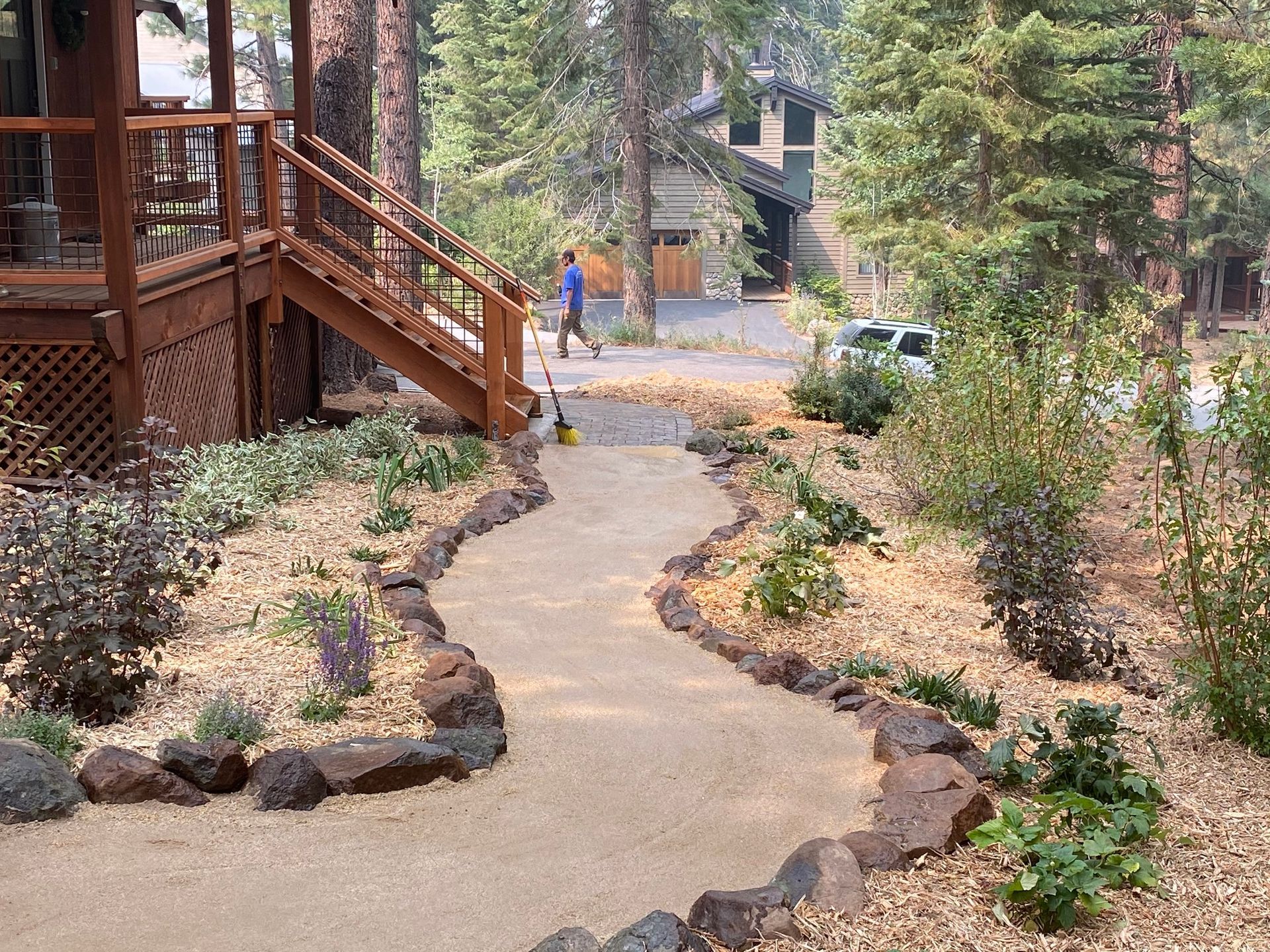 A man is walking down a path in front of a house.