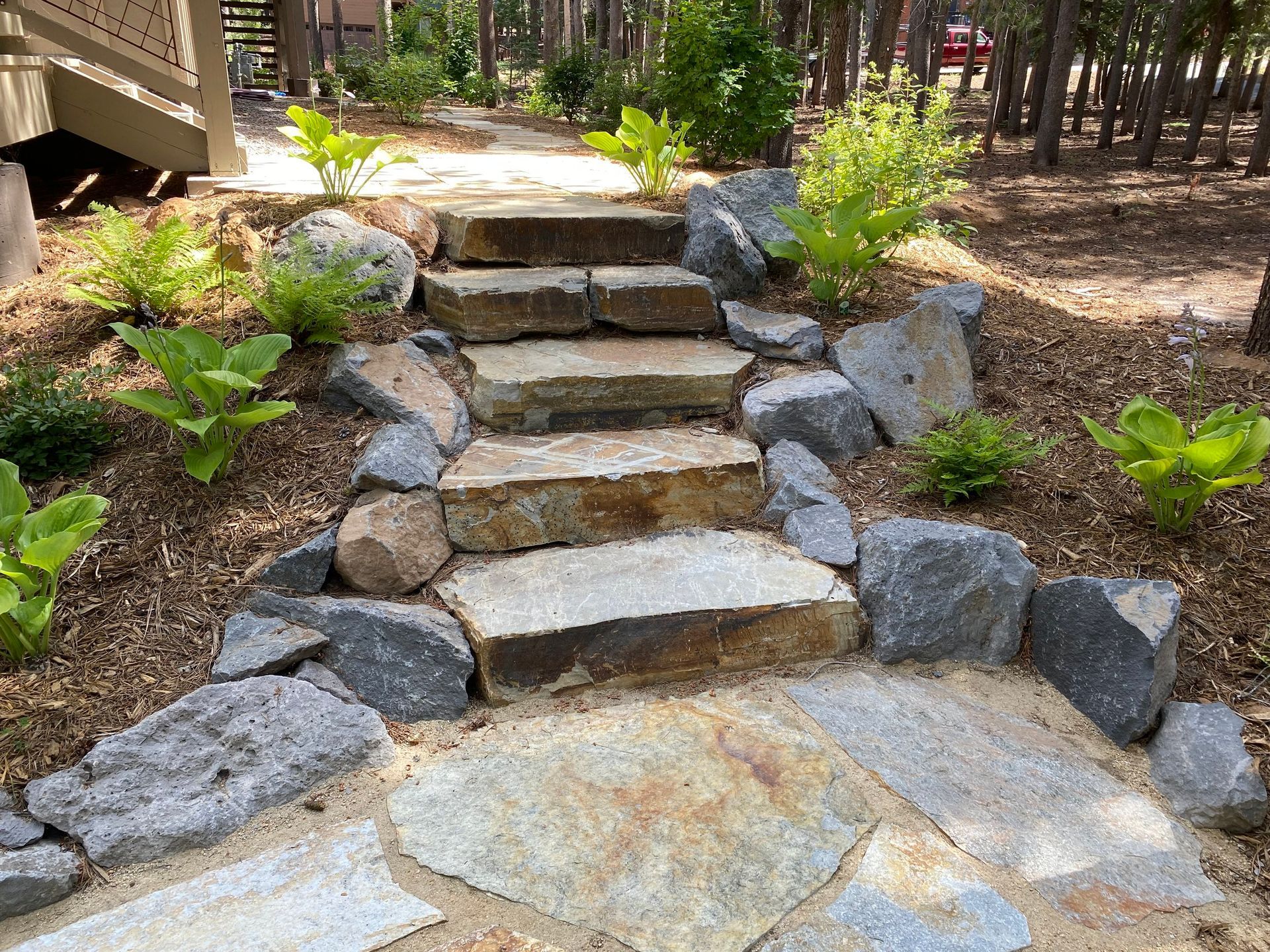 A stone walkway with stairs made of rocks in a garden.