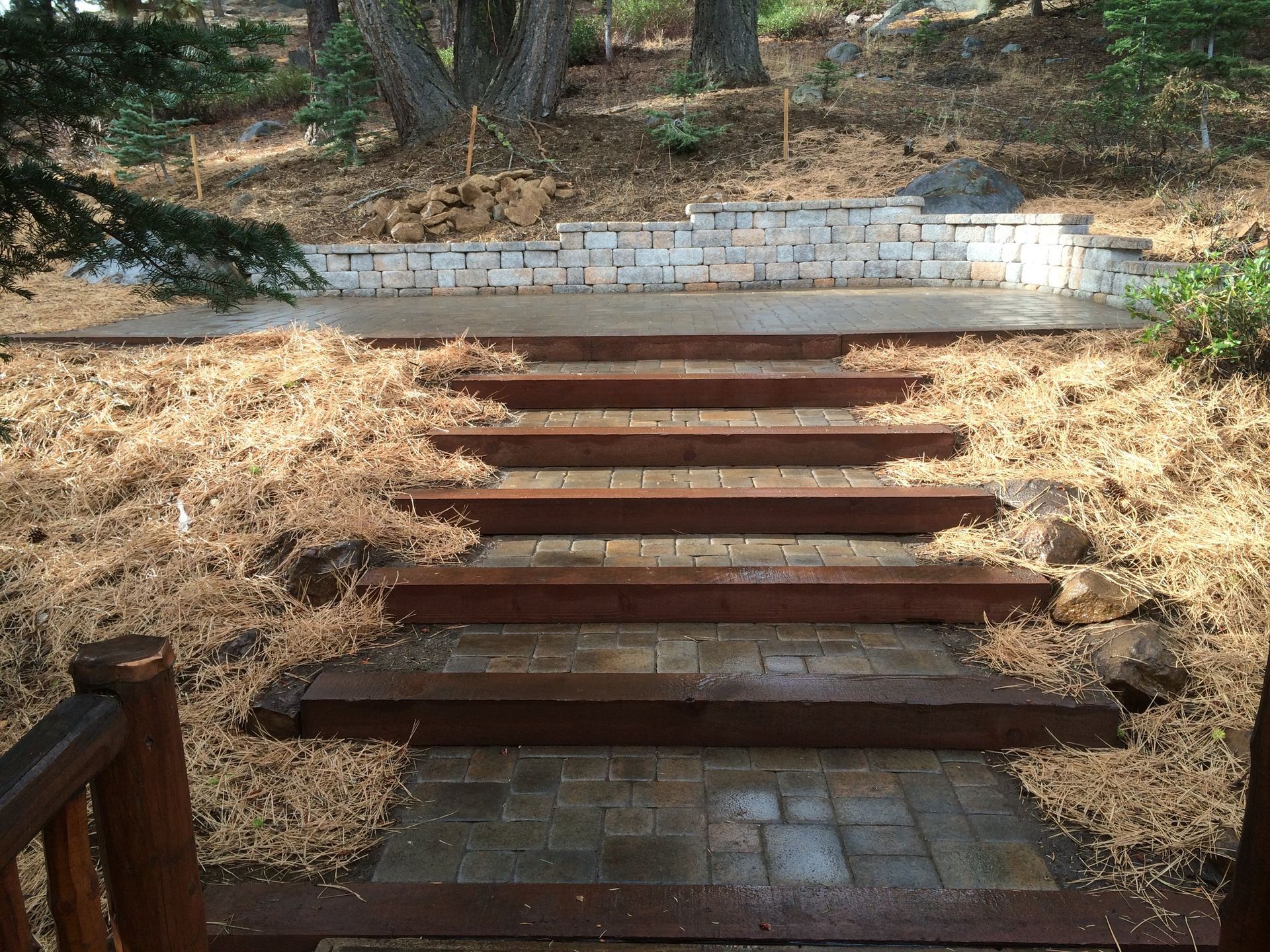 A set of wooden steps leading up to a stone wall