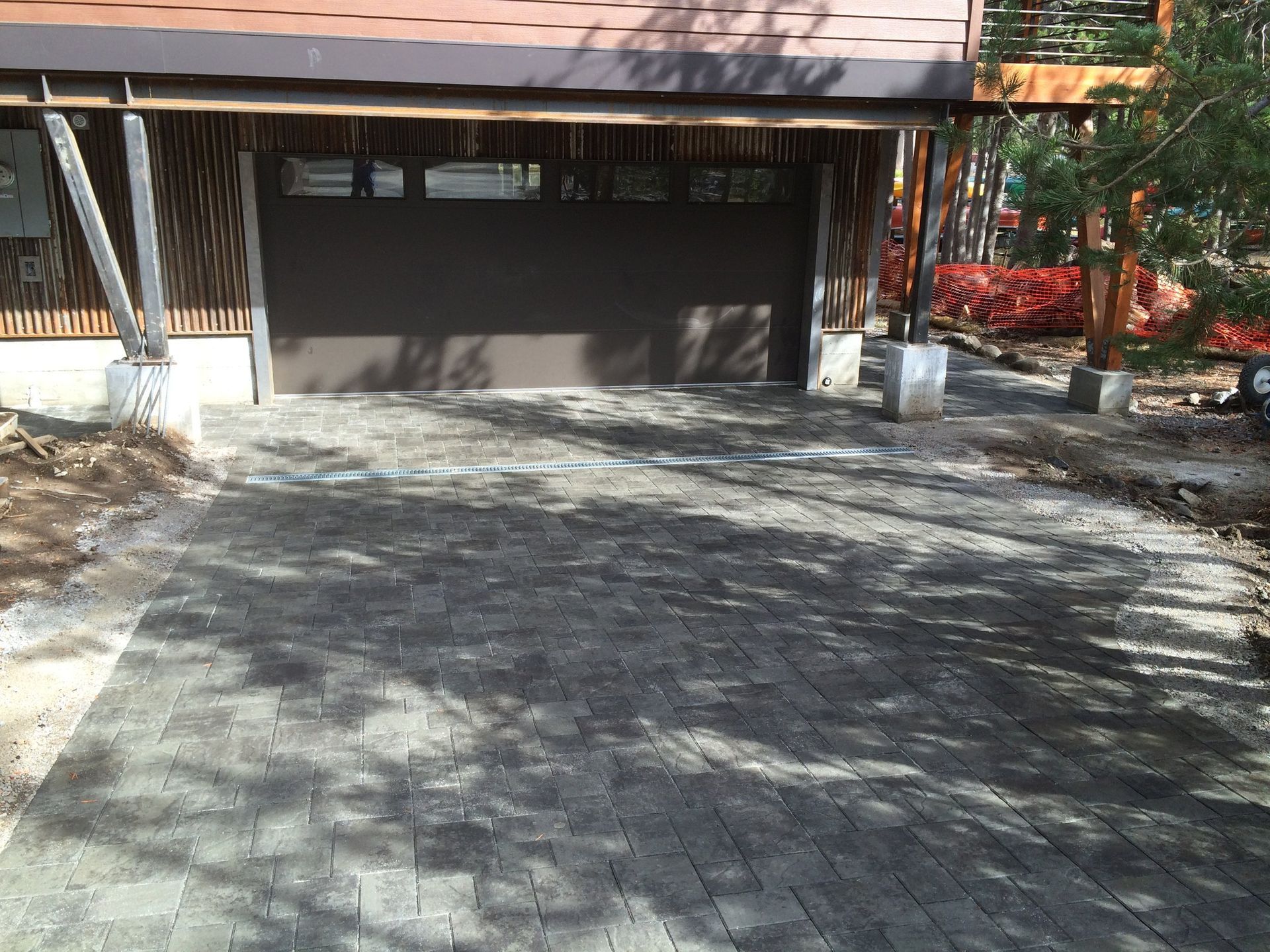 A brick driveway leading to a garage door of a house