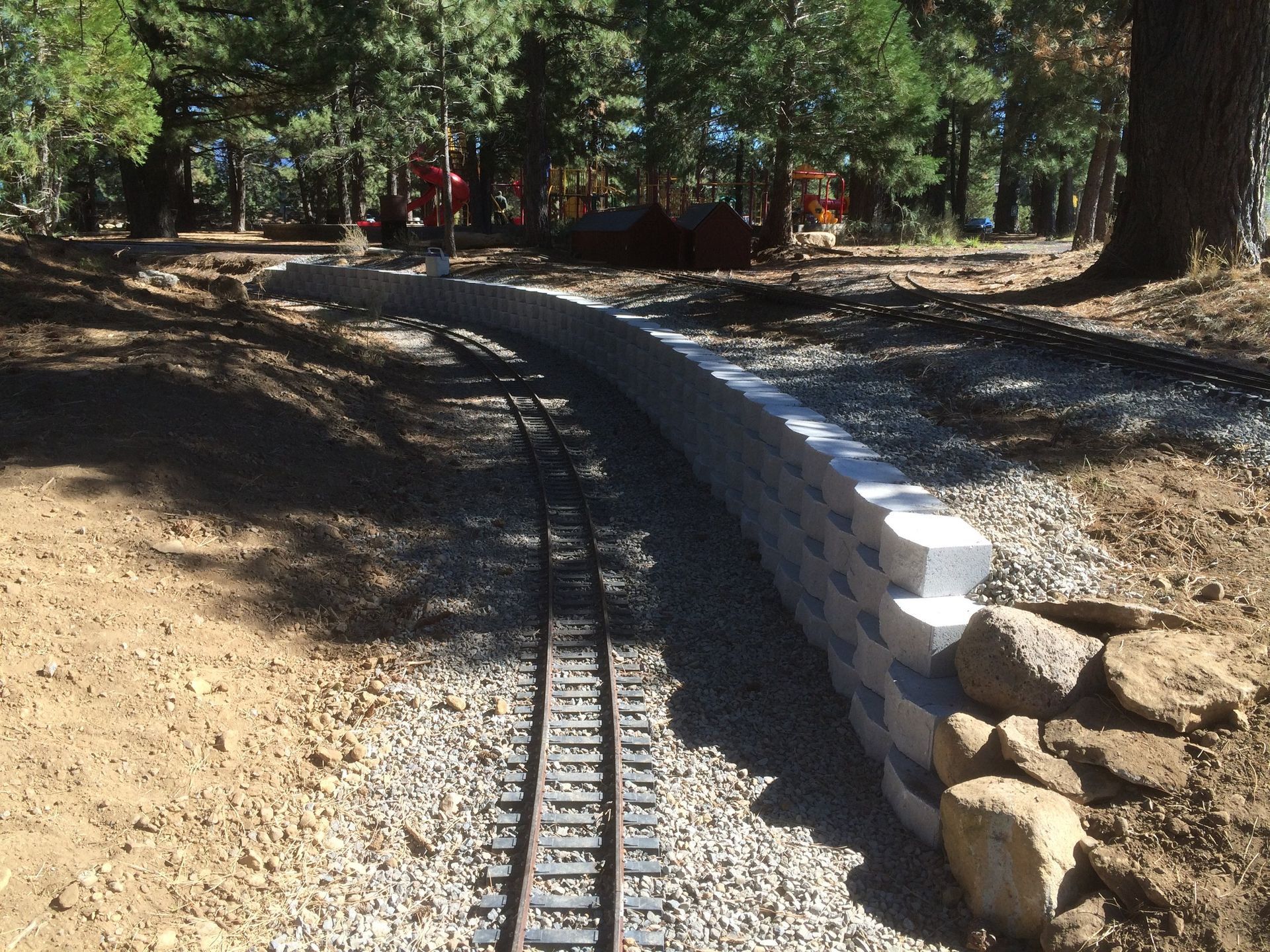 A train track with a stone wall along the side of it