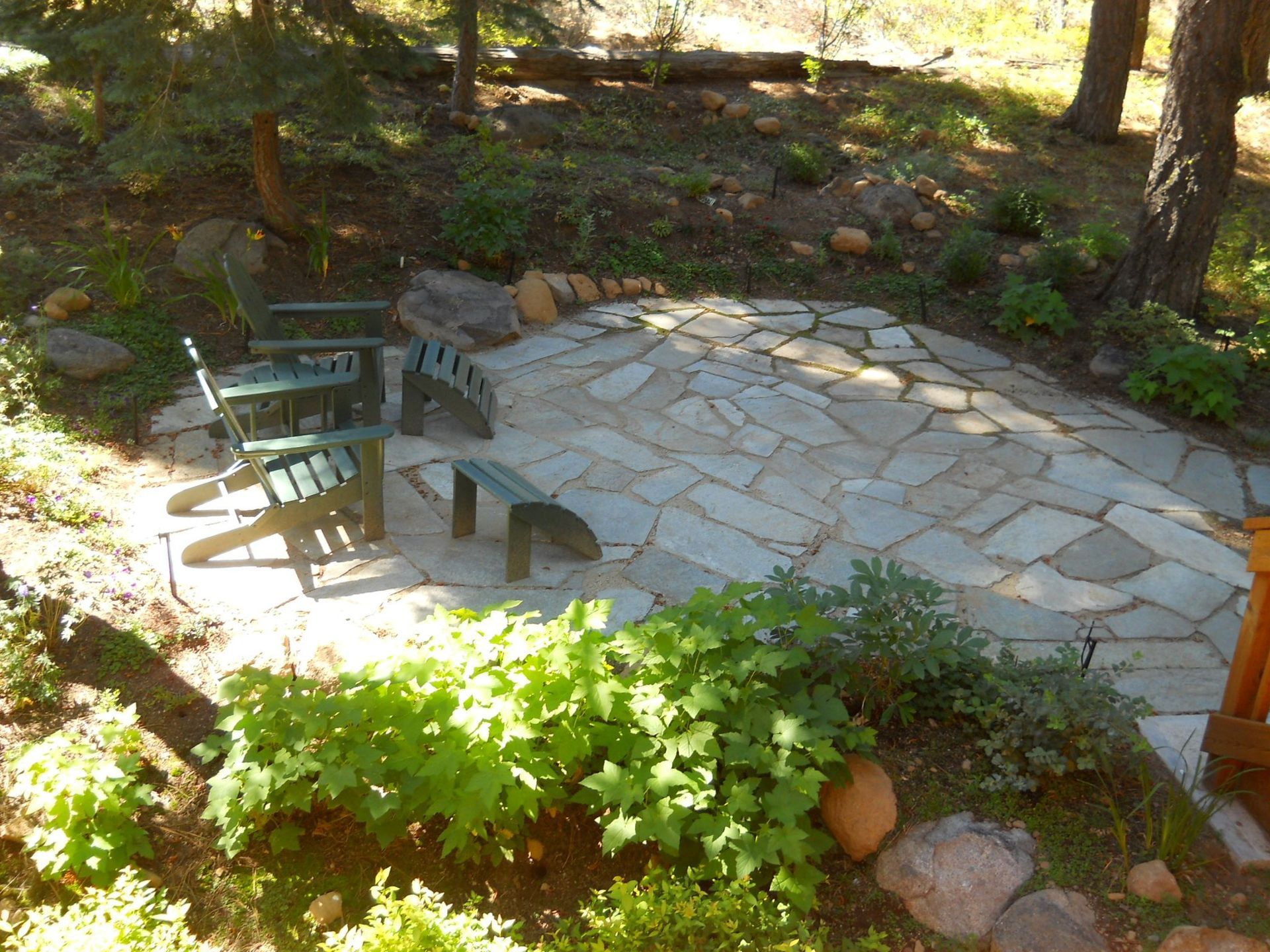 Two green chairs are sitting on a stone patio