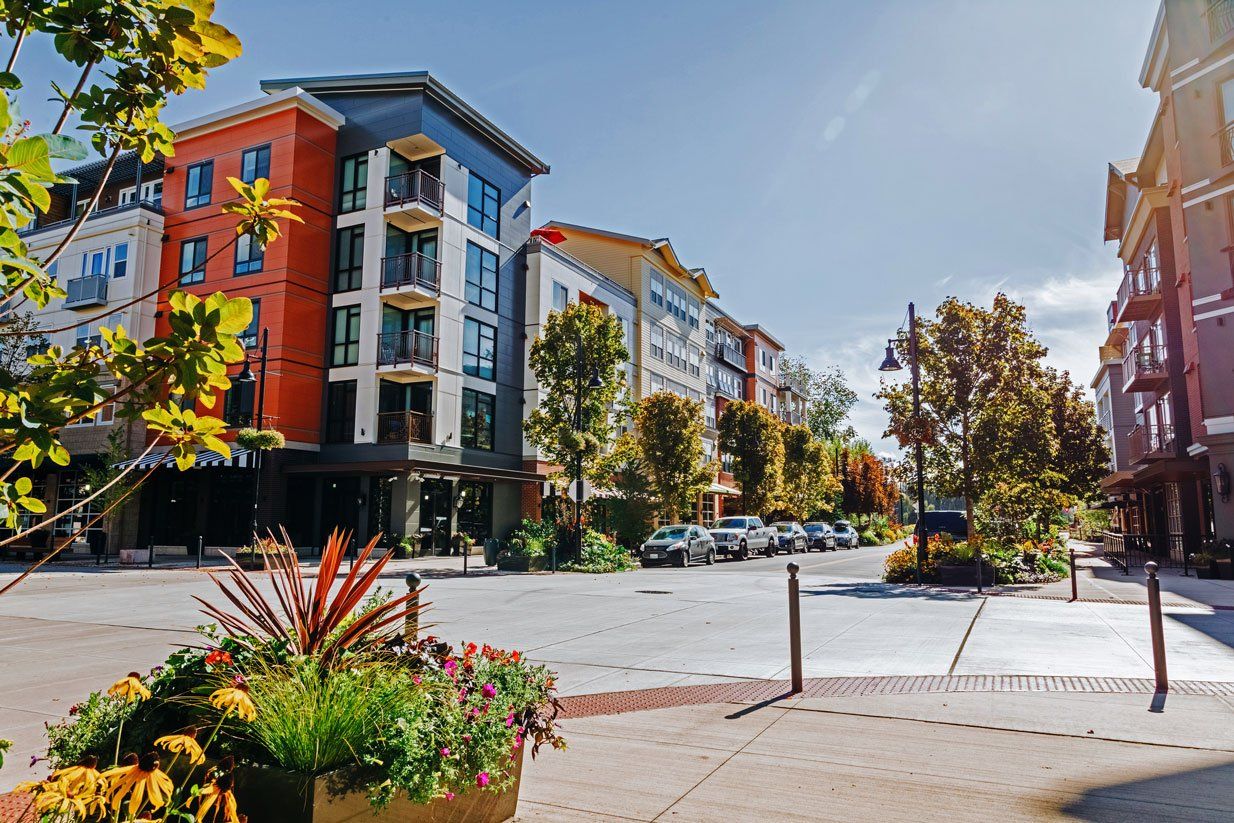 A row of buildings with flowers in front of them in a city at Woodin Creek Village.