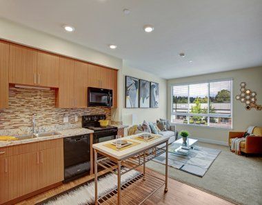 A kitchen and living room with a table in the middle of the room at Woodin Creek Village.