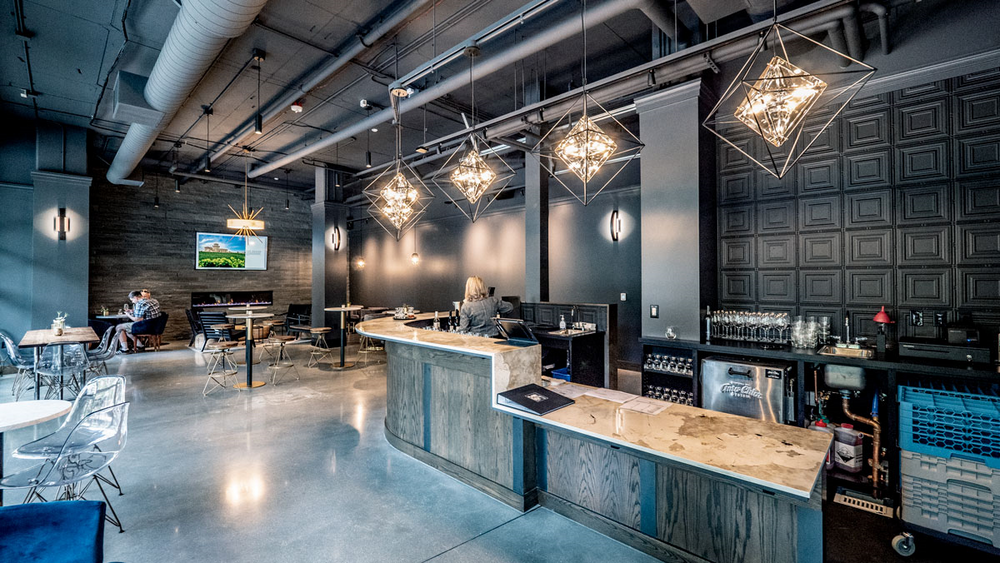 A restaurant with tables and chairs and a bar at Woodin Creek Village.