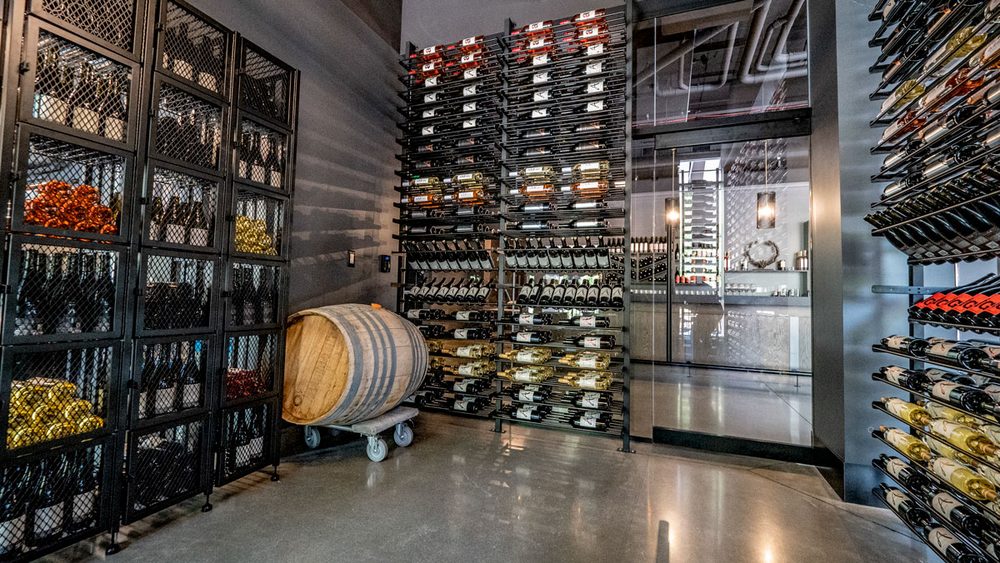 A large wine cellar filled with lots of wine bottles and a barrel.