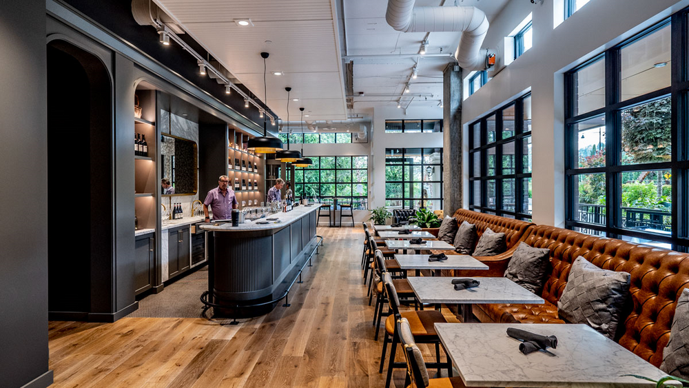A restaurant with tables and chairs and a bar.
