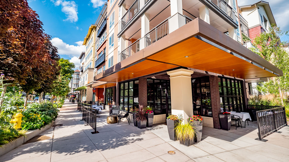A large building with a patio area in front of it.