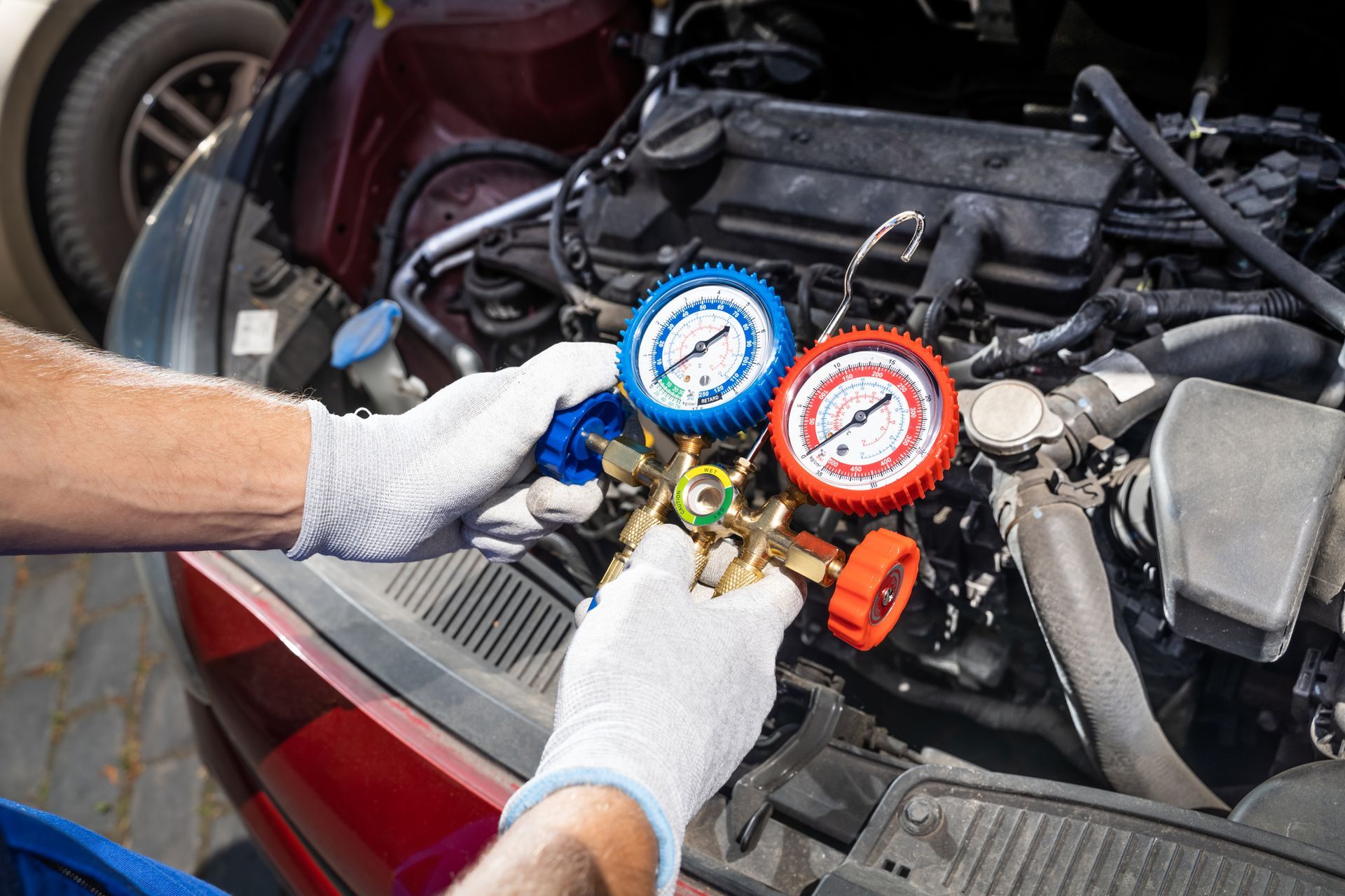 A man is working on the air conditioning system of a car.
