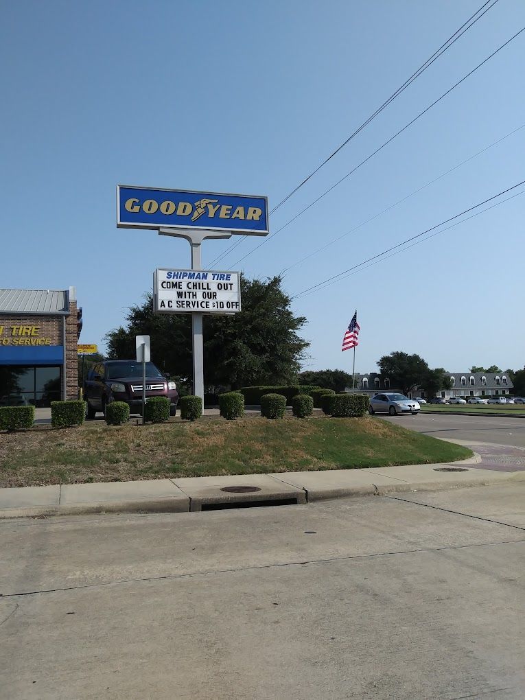A goodyear sign is on the side of the road