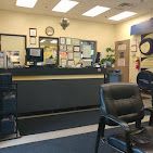 A waiting room with chairs and a counter in a hospital.