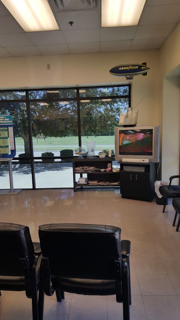 A waiting room with chairs and a television on a stand.