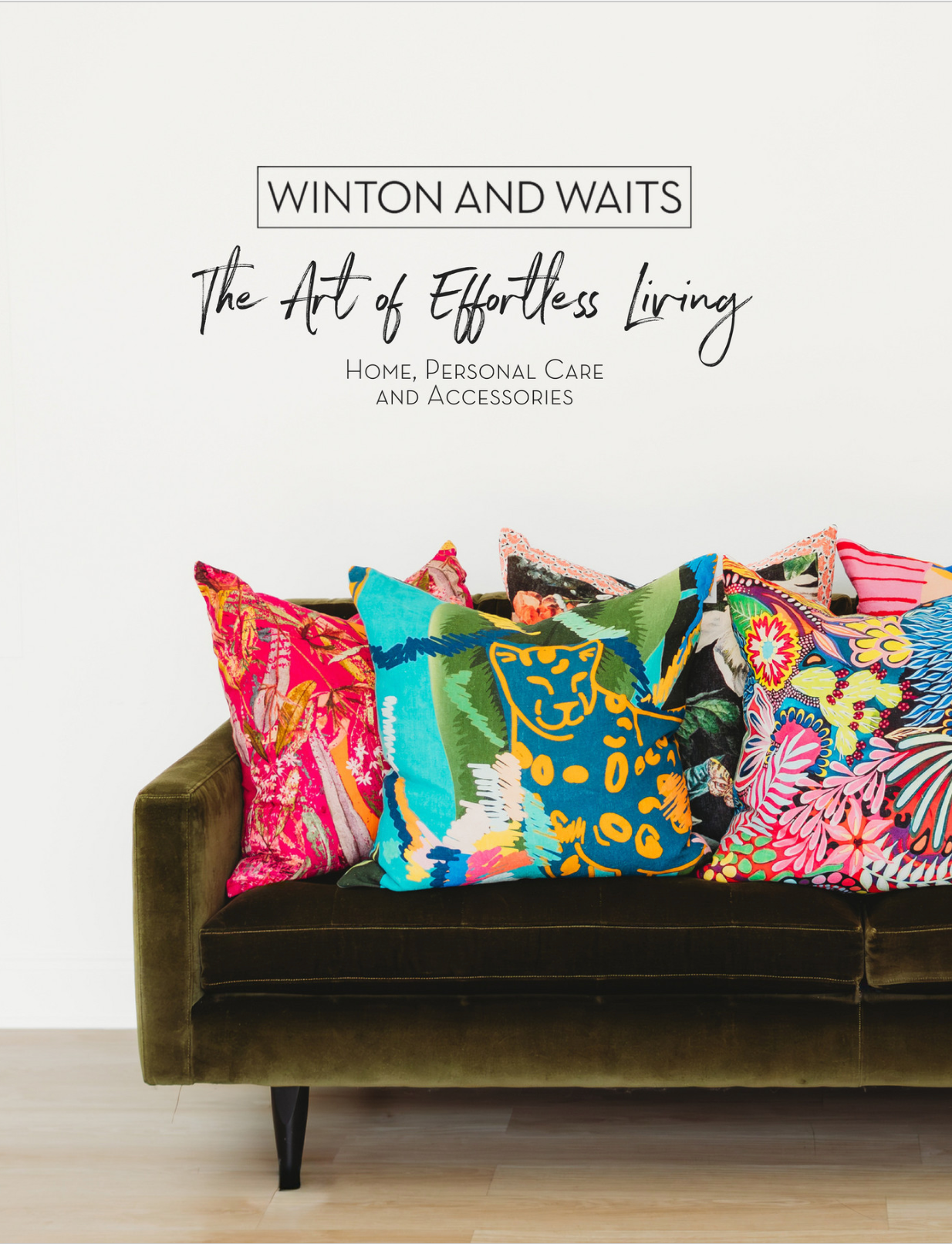 A green couch with colorful pillows under a sign that says 