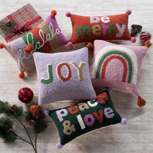 A group of christmas pillows are sitting on a wooden table.